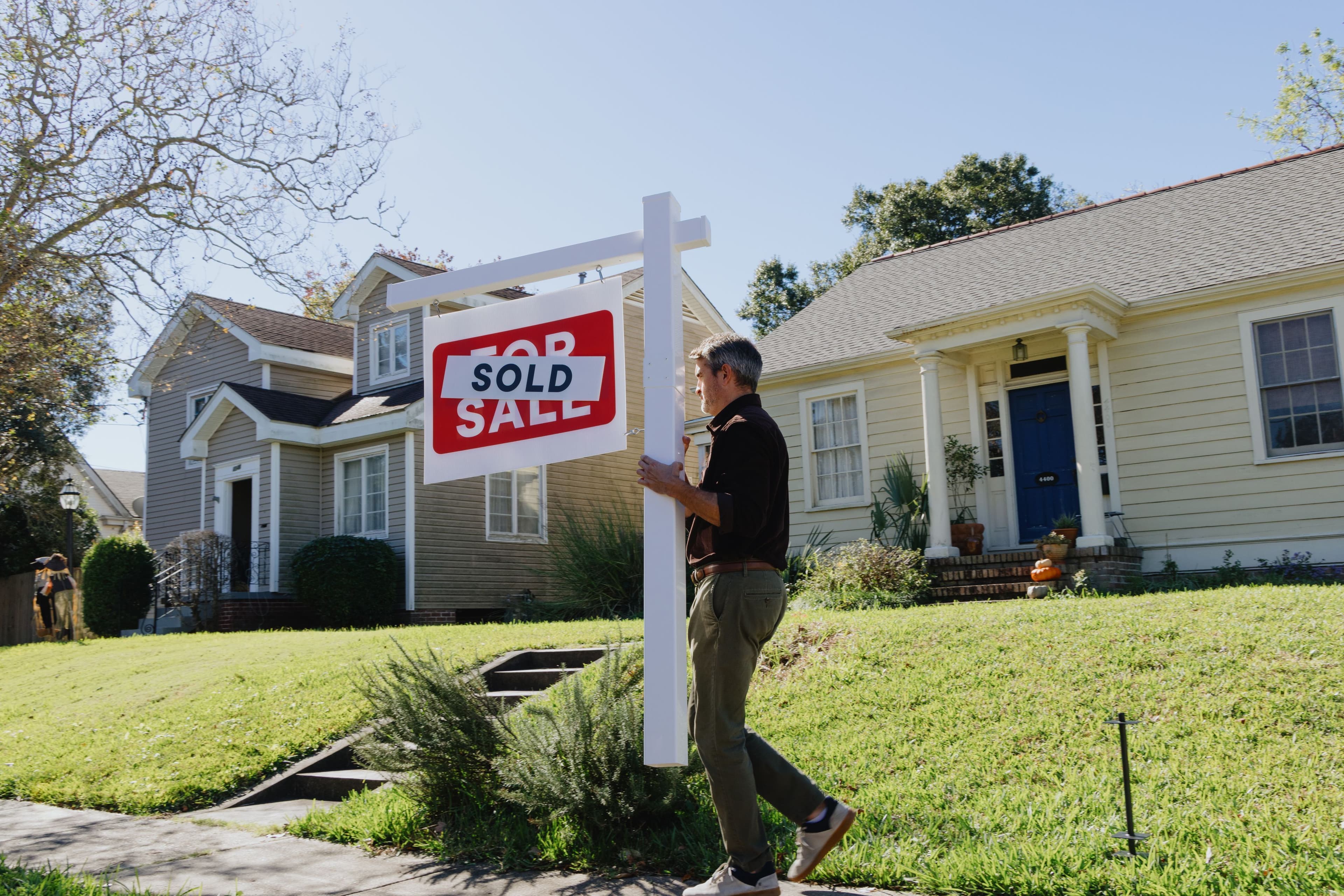 Person taking down sold sign